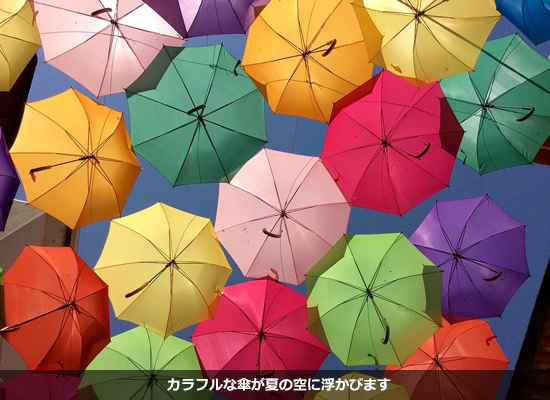 カラフルな傘が夏の空に浮かびます